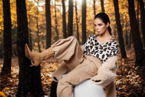 ragazza con power suit seduta su sfondo di bosco autunnale