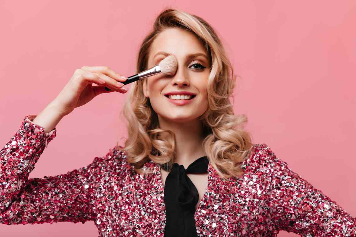 ragazza con pennello trucco sul viso